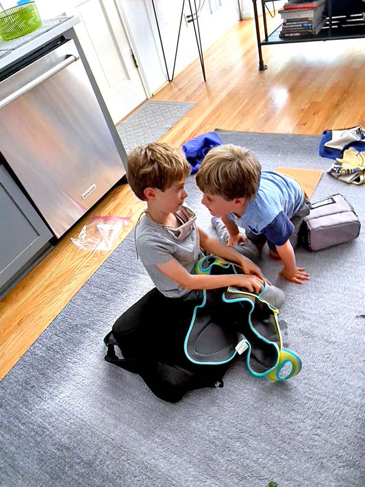 Two kids playing on the carpet after school.