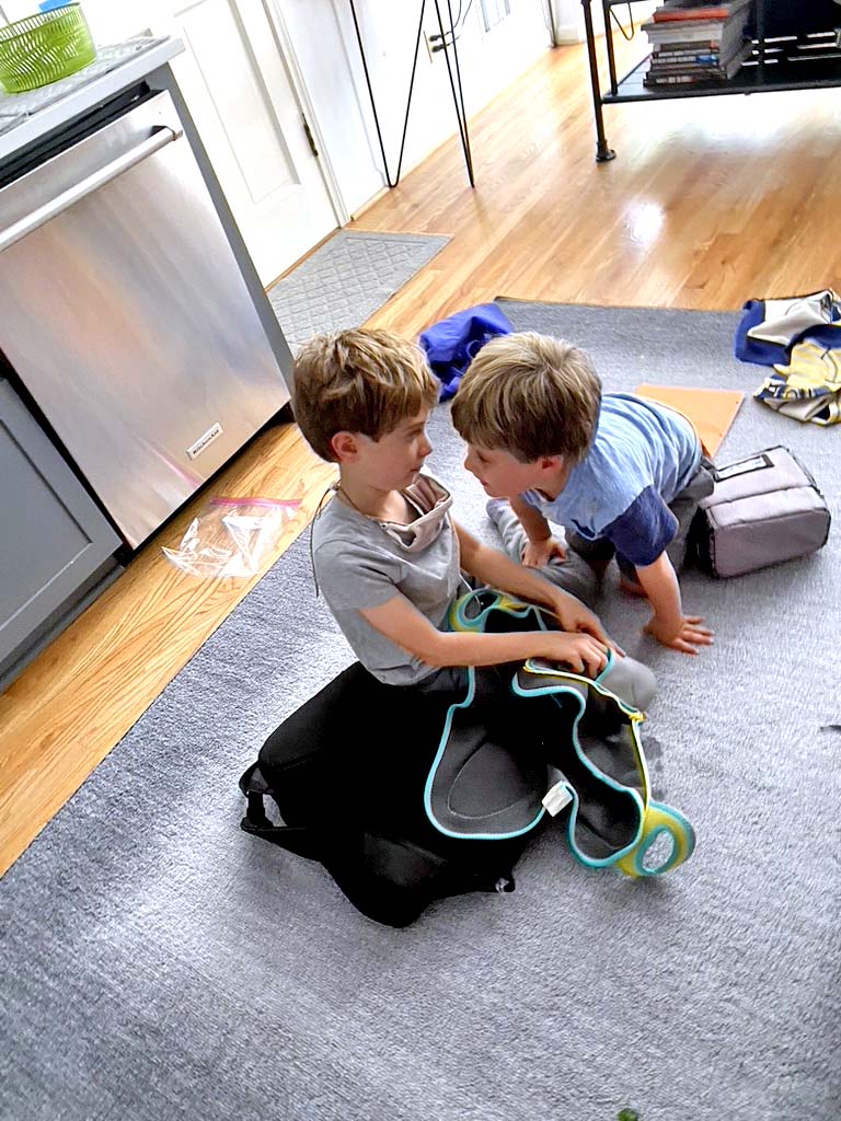 Two kids playing on the carpet after school.